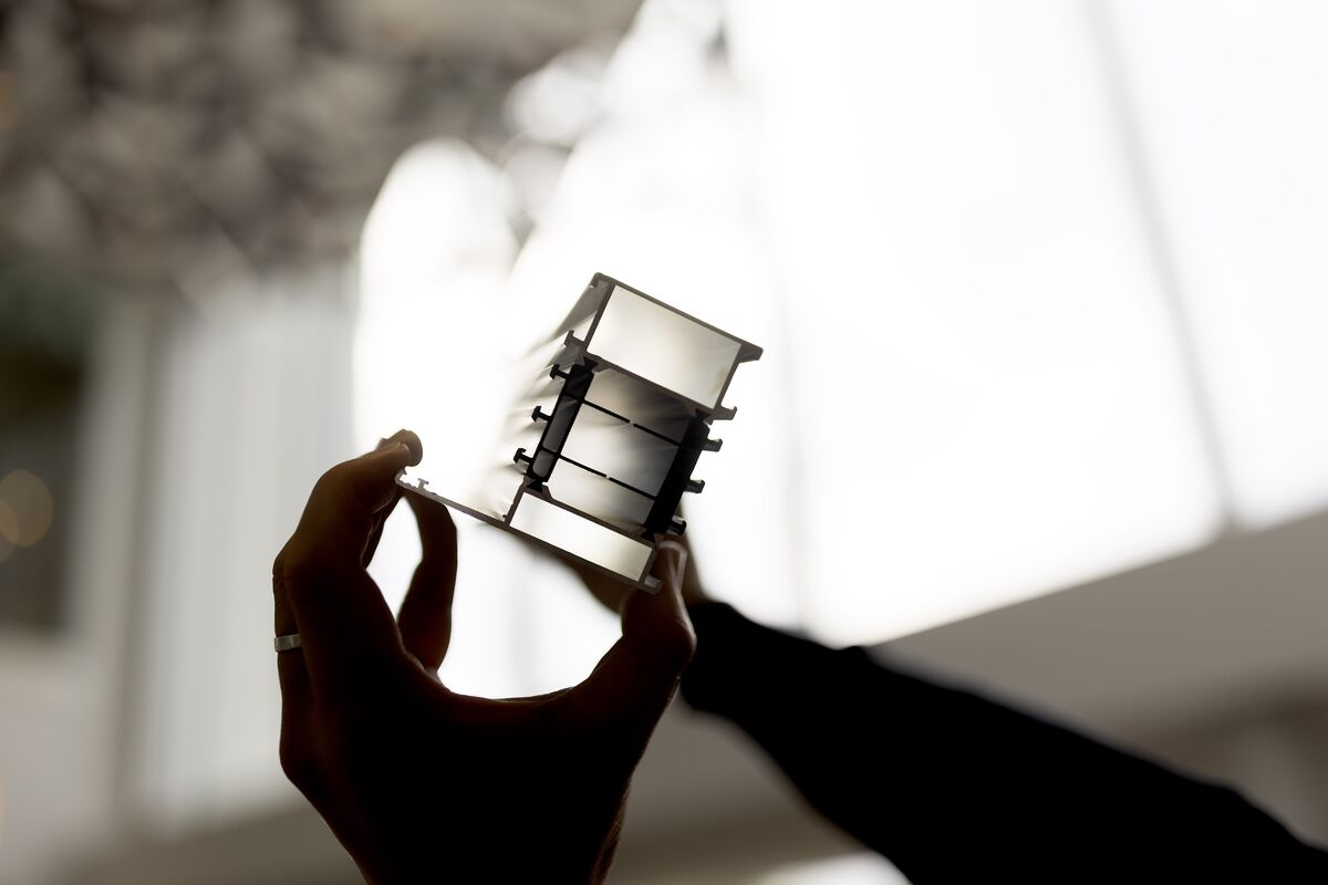 Schatten eines isolierten Aluminiumprofils, das von zwei Händen gehalten wird.