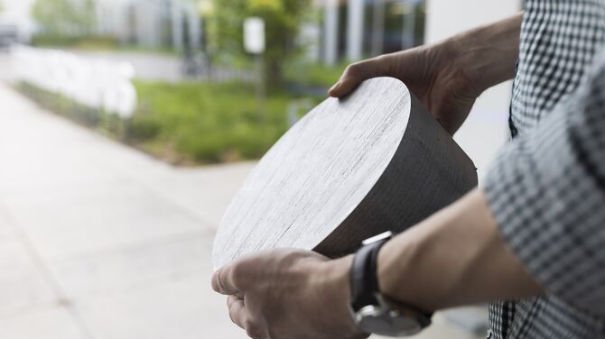 Mann mit Aluminiumknüppelprobe.