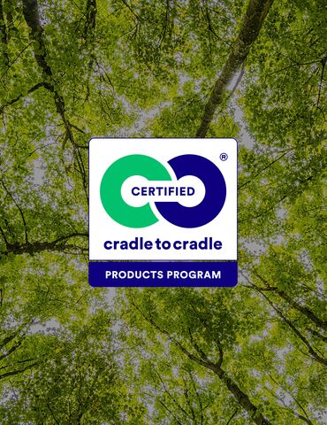 Cradle to Cradle Logo vor grünen Baumkronen.